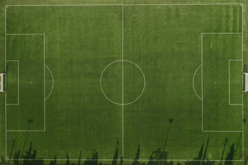 Aerial top down drone photo of green football pitch empty to be used for soccer game