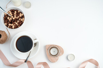 Romantic background with a Cup of coffee, a plate of round cereal, hearts, candles and a ribbon on...