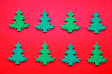Winter festive decoration with green fir trees on red background. Christmas or New Year minimal flat lay concept for design.