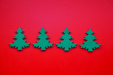 Winter festive decoration with green fir trees on red background. Christmas or New Year minimal flat lay concept for design.Selective focus.