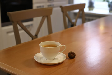 Mug with coffee on the table in the kitchen
