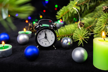 Midnight on a clock. Christmas tree, candles and holiday decoration. Merry Christmas or Happy New Year greeting card.