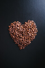 Heart shaped coffee beans on dark background