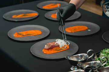 lightly greased tuna fish on a blck ceramic plate