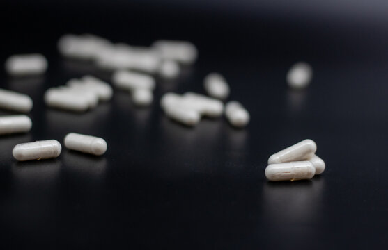 White pills on black background