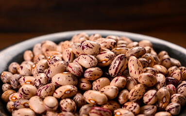 Colored beans on wooden background.