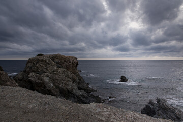 Fototapeta na wymiar un ciel orageux et des rochers sur la plage.