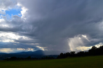 Fototapeta na wymiar Regenschauer, Sonnenstrahlen und Gewitterwolken