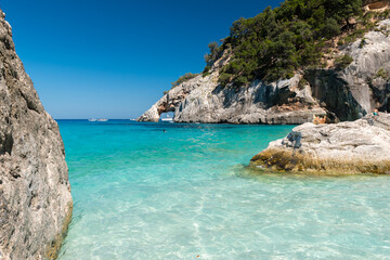 The coastline in Cala Goloritze, famous beach in the Orosei gulf (Ogliastra, Sardinia, Italy) with a natural arch in the background