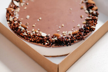 Homemade chocolate cake with nuts. Food delivery. Homemade baking. Top view. Delicious tart with chocolate and nuts in a cardboard box. Side view.