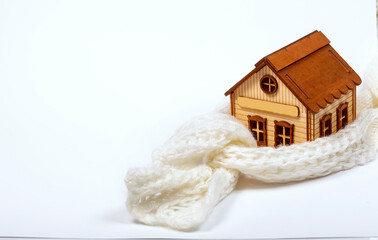 The toy house is wrapped in a white knitted scarf