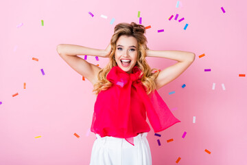 Obraz na płótnie Canvas happy woman on pink background with falling confetti