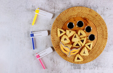 Traditional jewish carnival holiday Purim celebration and hamantaschen cookies, noisemaker and mask,