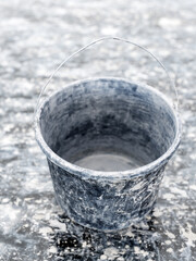 Plasterer's empty bucket on clay patched floor