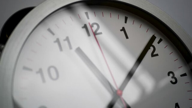 Close up of a ticking clock on white background, window reflection