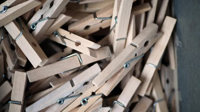 Hand taking wooden clothing pins from a box