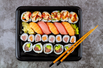 Delicious fresh sushi roll set on a black tray. Japanese food.