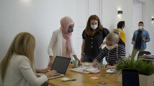 Freelancers wearing masks during meeting in coworking space