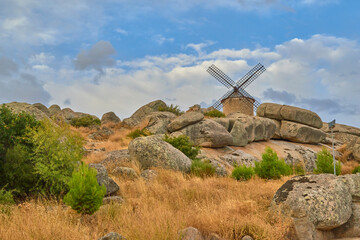 Nice image of mill with blades and vegetation in Las Ventas with Peña Aguilera, Toledo, Spain