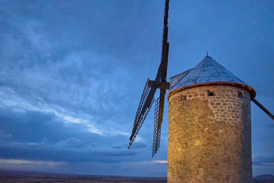 Windmill on the side and bottom a village at sunset in Las Ventas with Peña Aguilera, Toledo, Castilla La Mancha, Spain