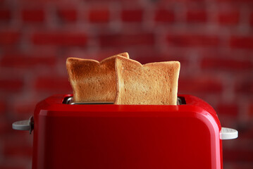 toaster with toasted sliced bread on wooden background. Kitchen equipment - obrazy, fototapety, plakaty