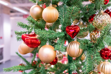 green pine tree decorated for christmas and golden yellow balls with red heart on it. tree decoration concept.