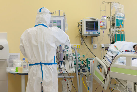 Male Nurse With Protective Coverall Clothing In Intensive Care Unit In Hospital, Where Are  Treated Patients With Pneumonia Caused By Coronavirus Covid 19.