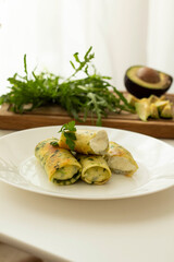 rolled pancakes stuffed with spinach and feta cheese. Green unusual spinach pancakes. Love for a healthy vegan food concept
