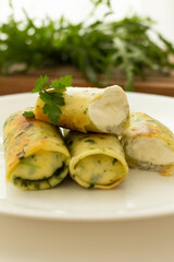 rolled pancakes stuffed with spinach and feta cheese. Green unusual spinach pancakes. Love for a healthy vegan food concept
