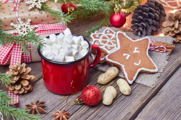 Christmas wooden background with a mug of hot drink and a fir branch. Happy Christmas and new year.