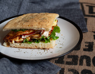 Craft food. Delicious juicy sandwich with chicken, fried egg, tomato and fresh salad.