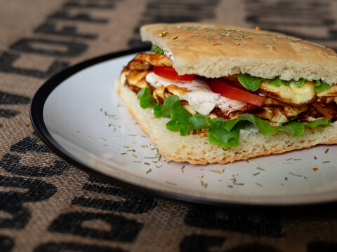 Craft food. Delicious juicy sandwich with chicken, fried egg, tomato and fresh salad.