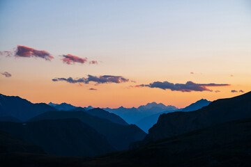 Colorful dawn landscape with beautiful mountains silhouettes and golden gradient sky with lilac...