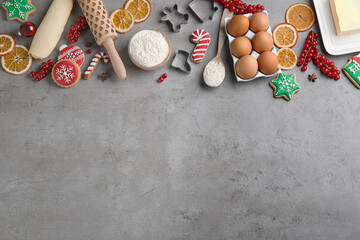 Flat lay composition with homemade Christmas cookies and ingredients on grey table, space for text