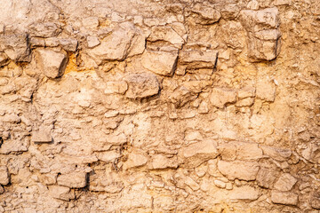 Background from stones. Hardened clay blocks in orange sunlight.