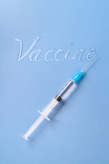 Liquid inscription Vaccine and a syringe on a blue background