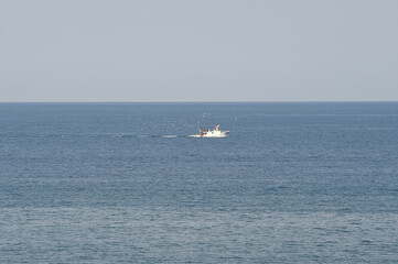 Obraz premium peschereccio al lavoro in mezzo al mare