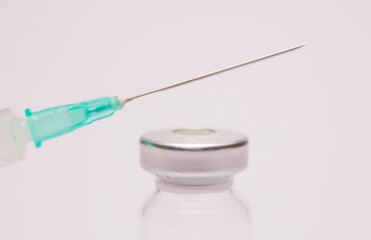 Syringe and vaccine in glass taro, closed isolated on white background