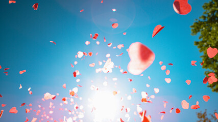Fototapeta premium BOTTOM UP: Pink and red pieces of paper in shape of hearts fall from heaven.