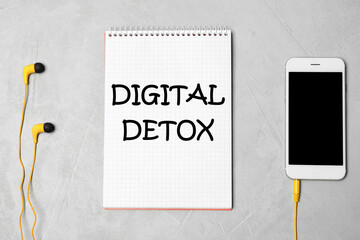 Notebook with text Digital Detox, headphones and smartphone on grey background, flat lay