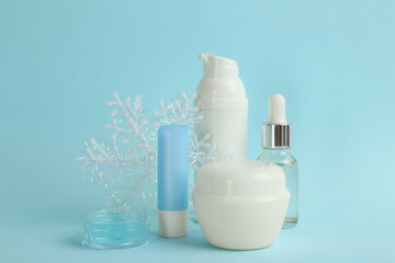 Beautiful composition with cosmetic products on cyan background. Winter care