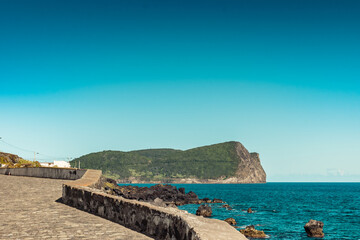 Seascape stone wall with Monte Brasil in the background, Terceira - Azores PORTUGAL