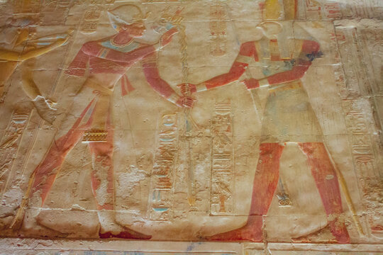 Hieroglyphics on the walls of temples of Egypt of a disciple making offerings to God Horus
