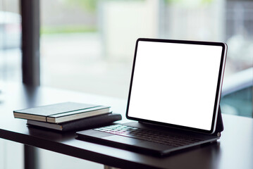 Mock up. blank screen digital tablet with office supplies on black wooden table.