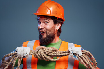 Emotional man in work uniform orange helmet rope professional