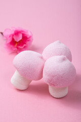 Pink and white marshmallow mushrooms on a pink background.