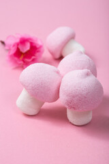 Pink and white marshmallow mushrooms on a pink background.