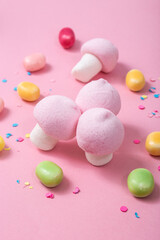 Fototapeta na wymiar Pink and white marshmallow mushrooms on a pink background.