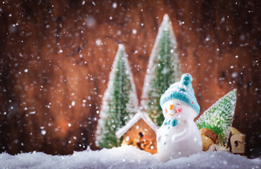 Merry Christmas and happy New Year composition with copy space. Little snowman carries Christmas tree from fairy forest to home. Winter festive background