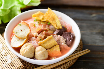 Thai food (Yen Ta Fo), Rice noodles soup with red sauce and fish tofu, pork ball and fried wonton in a bowl